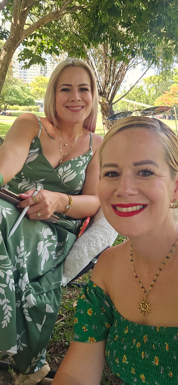 Mariluz y una de las gemelas lectoras comparten un momento vestidas de verde